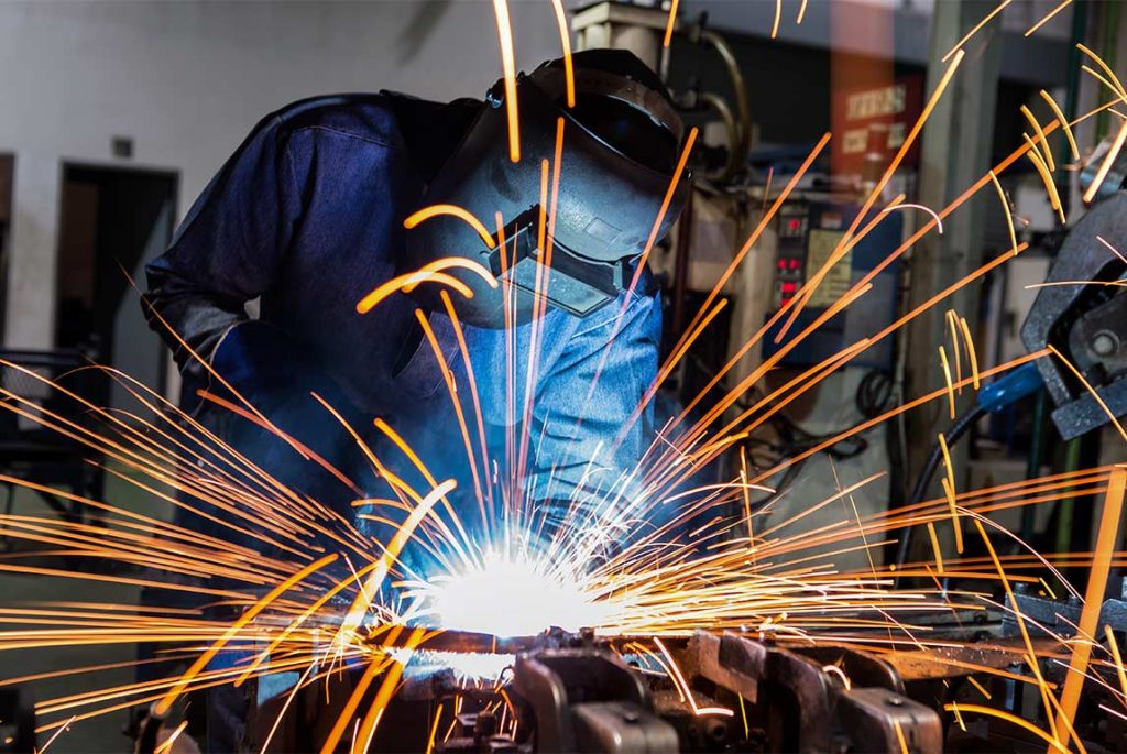 A welder creating sparks in a factory.
